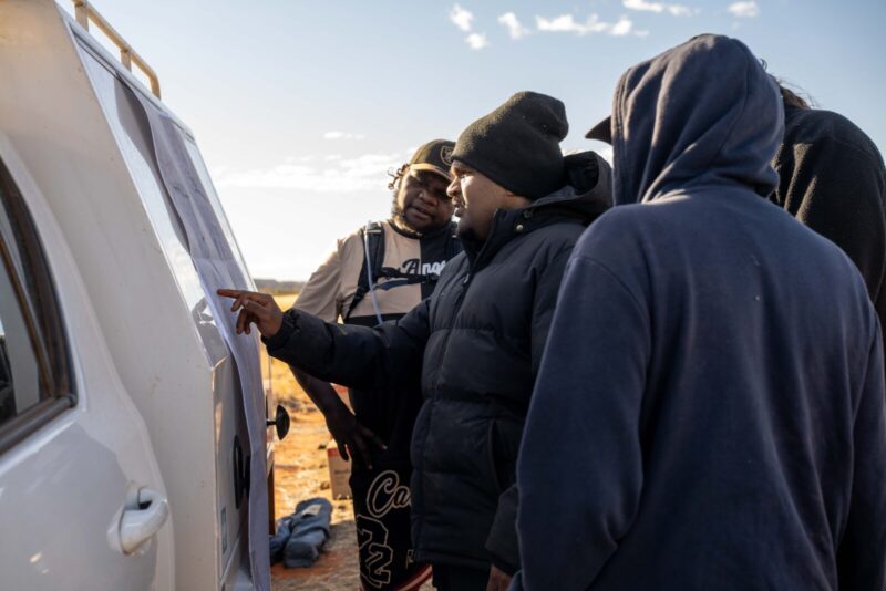 Young wati (man) consulting the map of the walk route